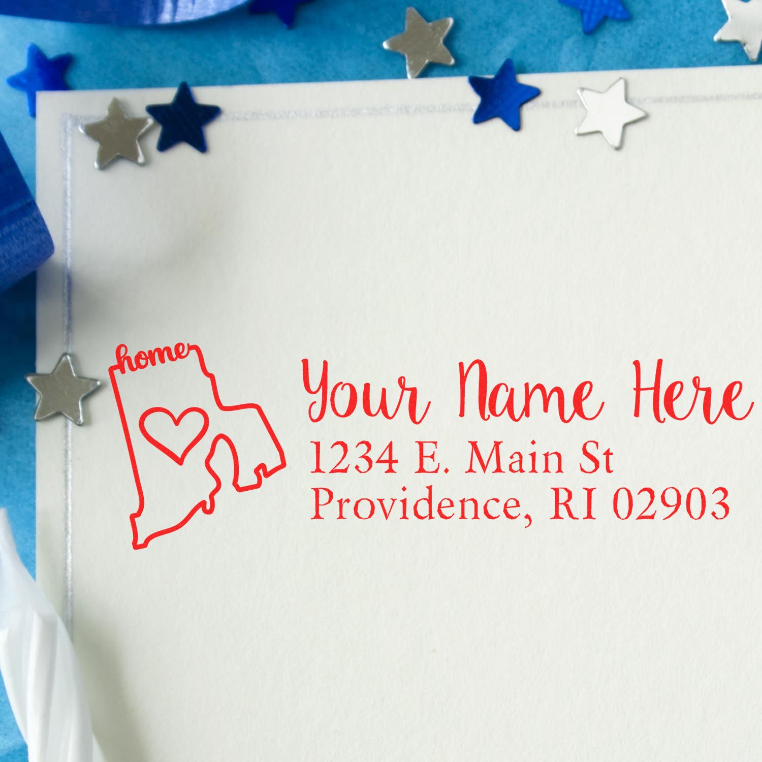 PSI Pre-Inked Personalized Rhode Island State Love Address Stamp on an envelope, featuring a red outline of Rhode Island with a heart, surrounded by decorative stars on a blue background.