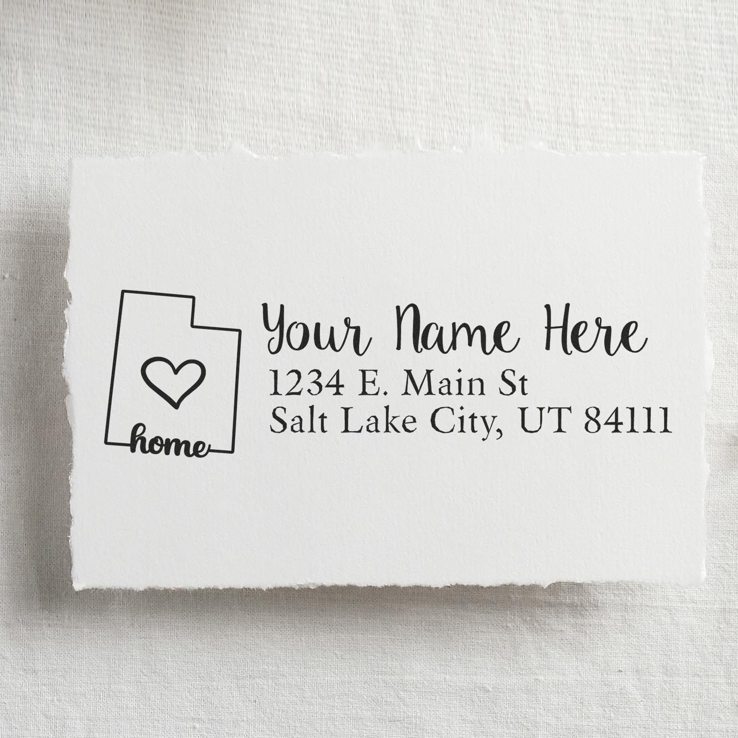 Wood Handle Utah Custom Address Rubber Stamp on white paper, featuring a heart design and sample address: Your Name Here, 1234 E. Main St, Salt Lake City, UT 84111.