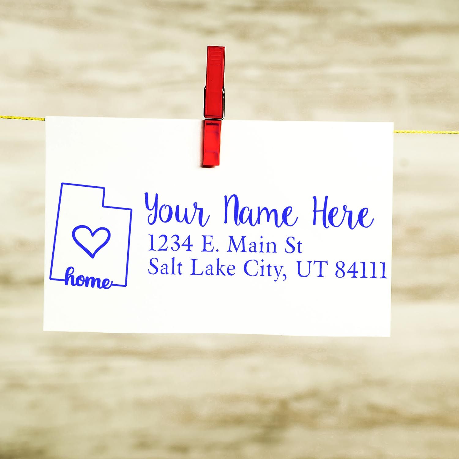 Wood Handle Utah Custom Address Rubber Stamp on white card with blue text, featuring a heart inside Utah outline. Card is clipped with a red clothespin against a wooden background.