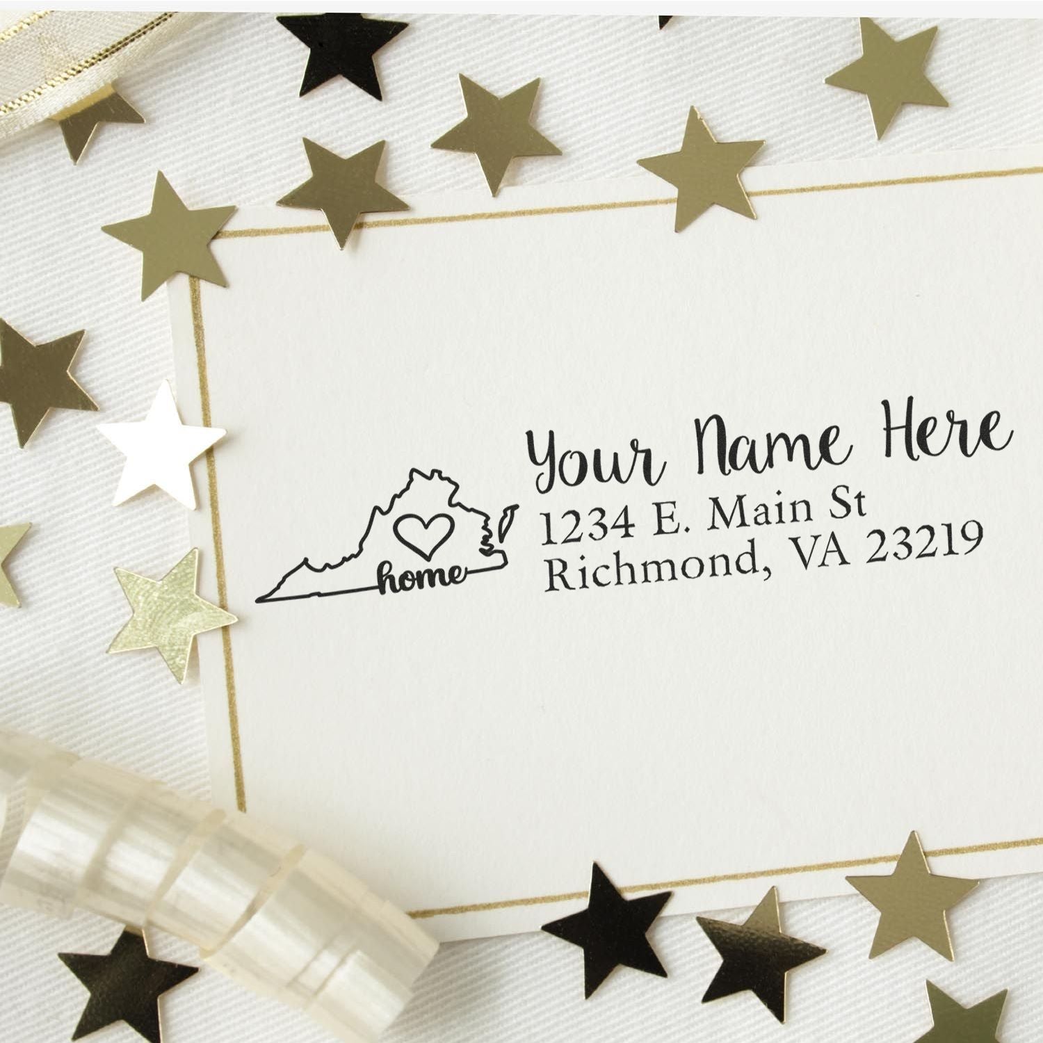 Wood Handle Virginia Custom Address Rubber Stamp on a card with a Virginia outline, heart, and sample address. Surrounded by gold stars and ribbon on a white background.