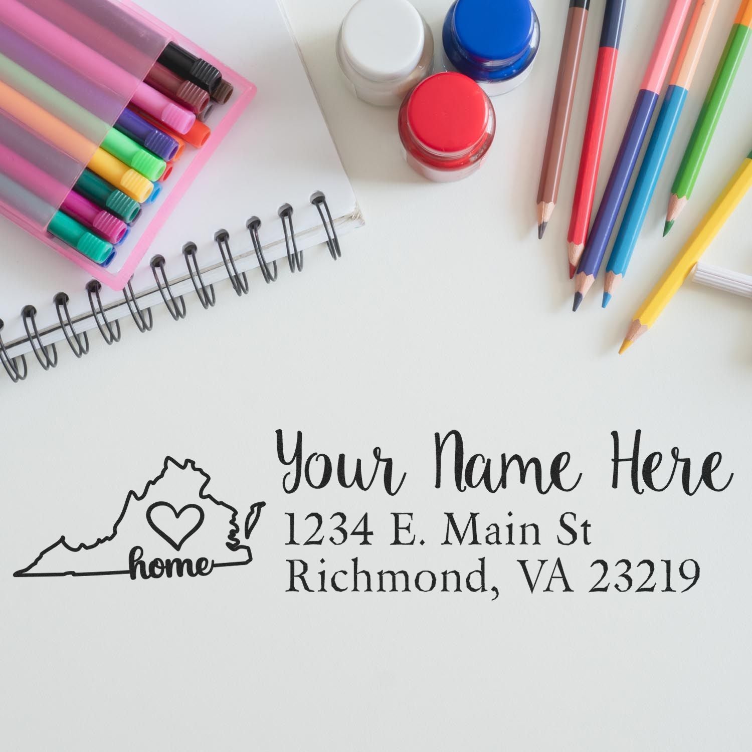 Wood Handle Virginia Custom Address Rubber Stamp on paper with colorful pens, markers, and paint jars nearby. The stamp features a heart design and customizable address text.