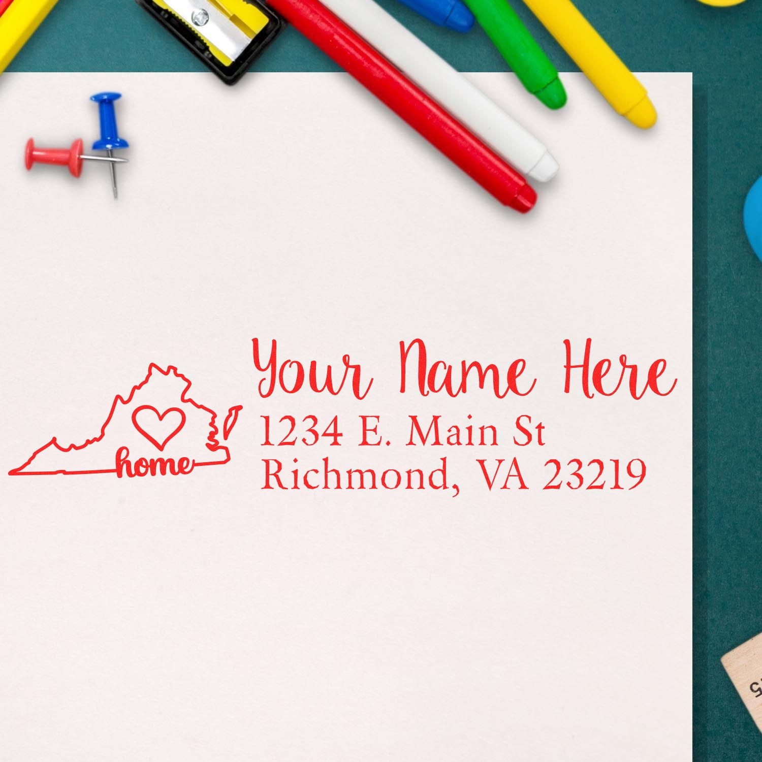 Wood Handle Virginia Custom Address Rubber Stamp on white paper, featuring a red outline of Virginia with a heart and the word home, alongside customizable address text. Surrounded by colorful stationery.