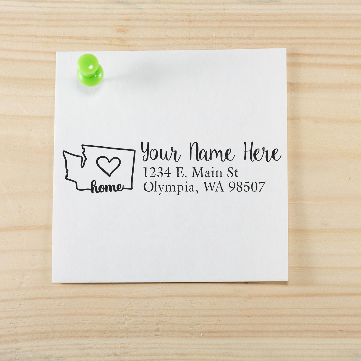 Slim Pre-Inked Washington State Love Custom Address Stamp on a white note pinned to a wooden board, featuring a heart inside the state outline and sample address text.