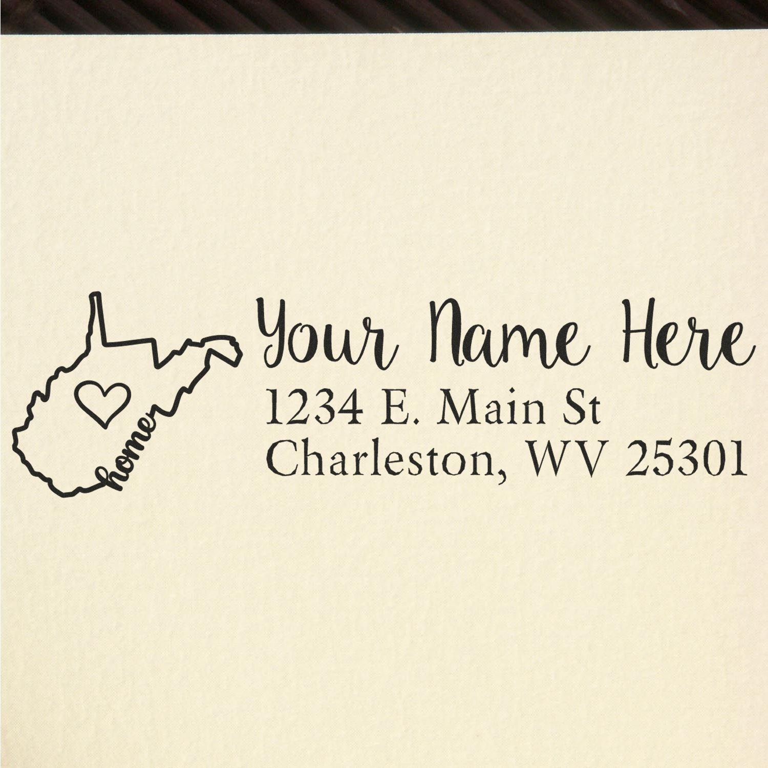 Wood Handle West Virginia Custom Address Rubber Stamp on paper, featuring a heart inside the state outline and personalized text: Your Name Here, 1234 E. Main St, Charleston, WV 25301.