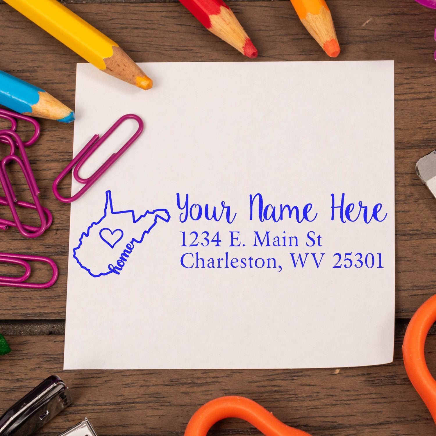 Wood Handle West Virginia Custom Address Rubber Stamp on paper with colorful stationery, featuring a heart design and sample address in blue ink.