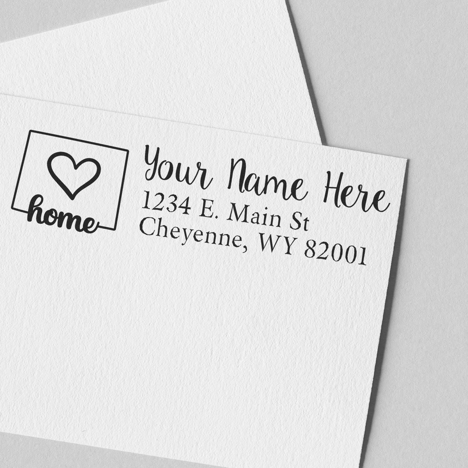 PSI Pre-Inked Personalized Wyoming State Love Address Stamp on white paper, featuring a heart and home design with customizable address lines in elegant black font.