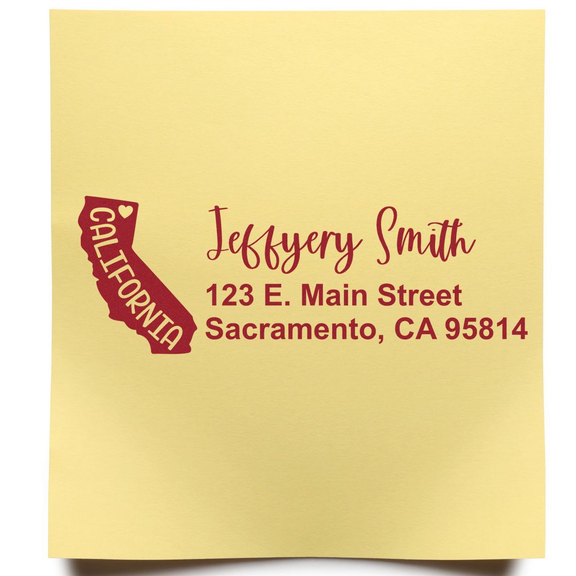 Yellow paper with red ink showing the State Love of California Custom Address Stamp Self-Inking. Features a California outline, heart, and sample address: Jeffery Smith, 123 E. Main Street, Sacramento, CA 95814.