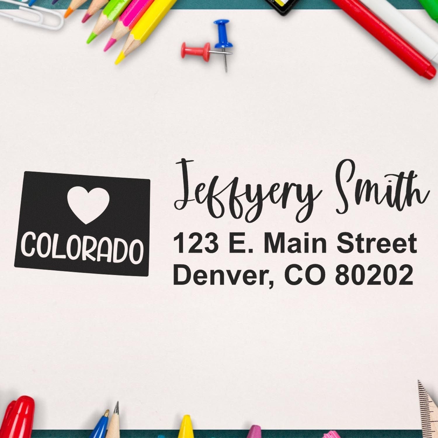 State Love of Colorado Custom Address Stamp Self-Inking on paper with colorful stationery, displaying 'Jeffery Smith, 123 E. Main Street, Denver, CO 80202' in stylish font.