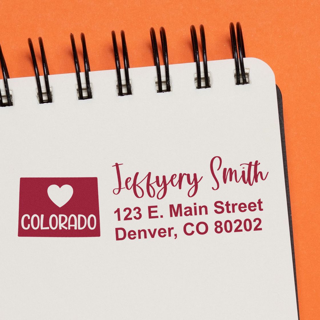 Slim Colorado Custom Address Stamp for Envelopes displayed on a notepad. Features a heart and Colorado design with sample address: Jeffery Smith, 123 E. Main Street, Denver, CO 80202.