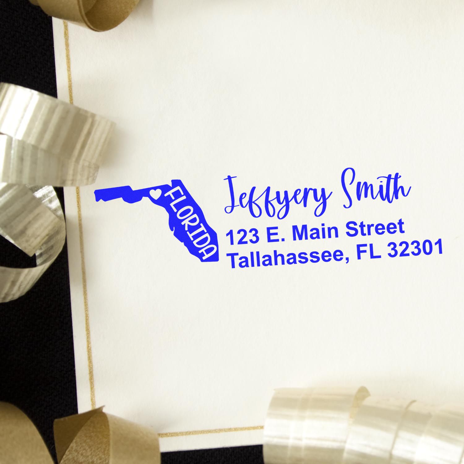 State Love of Florida Custom Address Stamp Self-Inking on an envelope, featuring a blue Florida state outline with address details. Decorative ribbons surround the envelope.