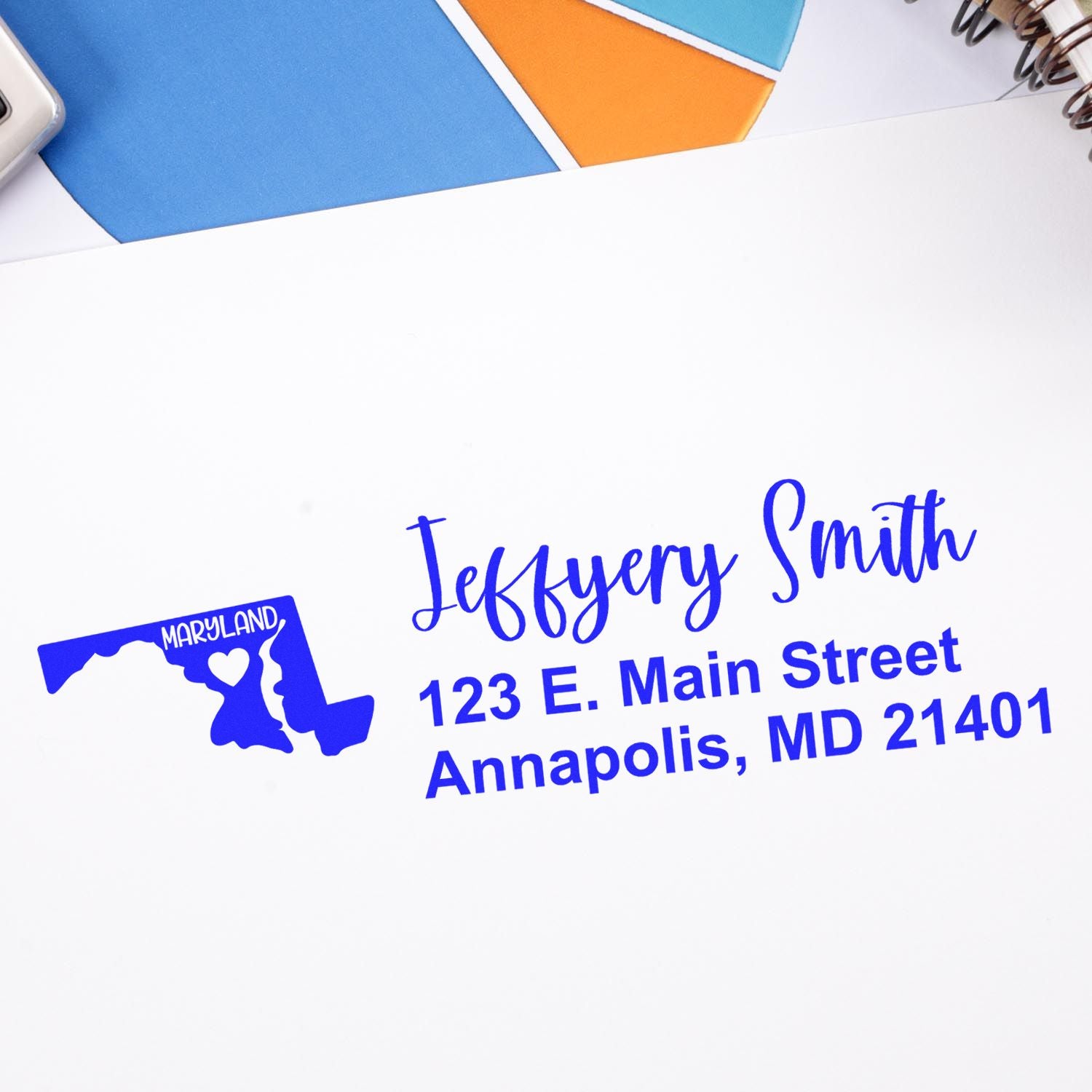 State Love of Maryland Custom Address Stamp Self-Inking in blue ink on white paper, featuring a Maryland map design with a heart, personalized with a name and address in a stylish font.