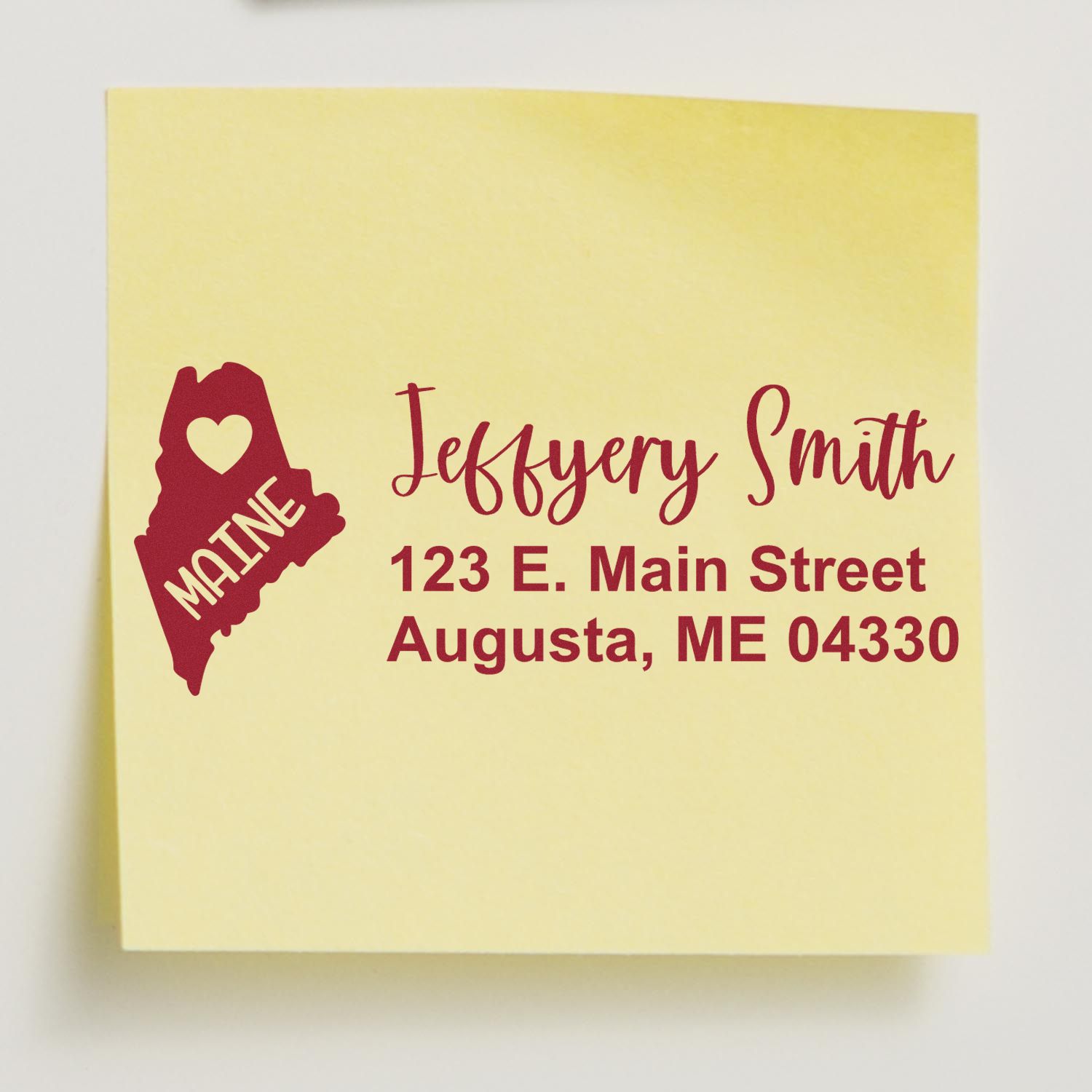 Yellow sticky note with red text showing the Maine State Love Personalized Address Stamp design, featuring a heart and the word Maine next to a sample address in a stylish font.