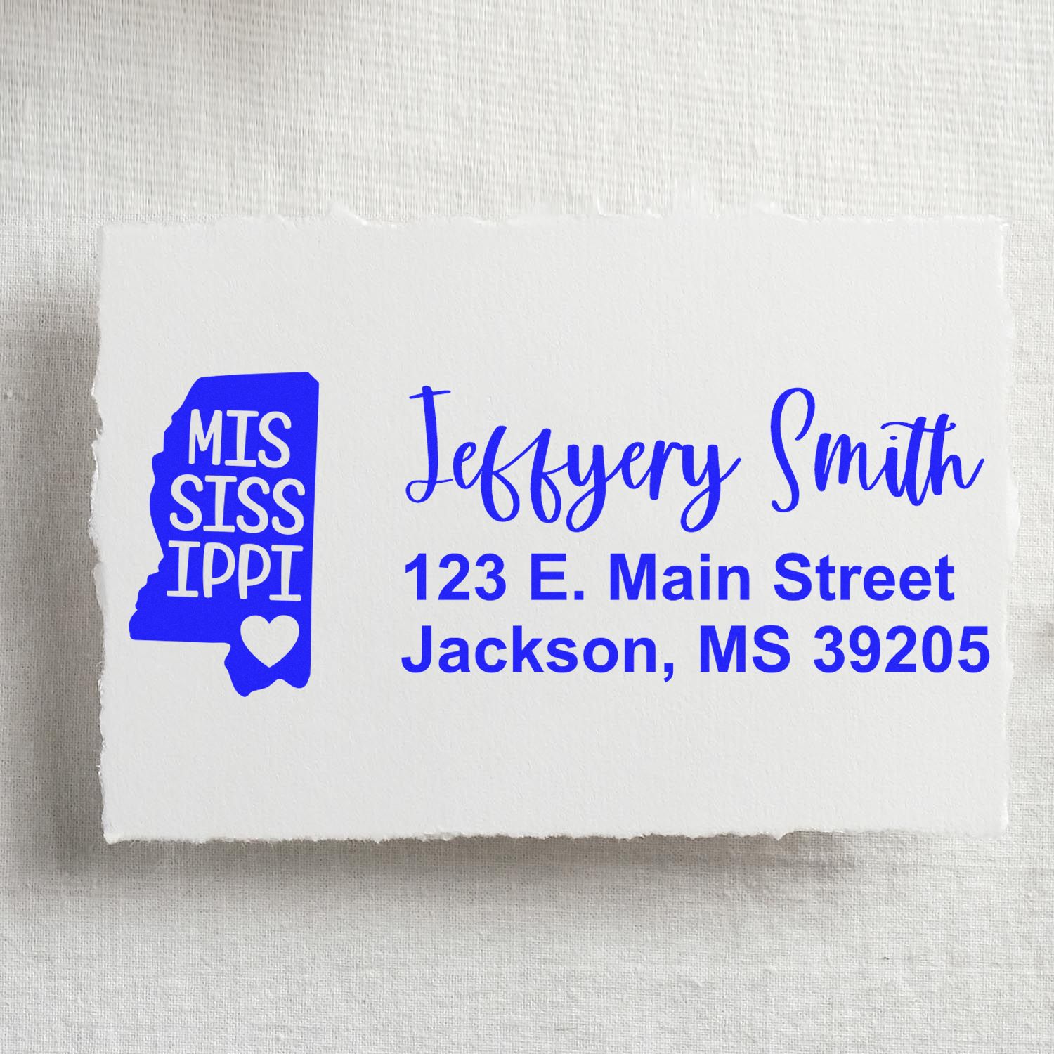 Mississippi State Love Personalized Address Stamp on white paper, featuring a blue state outline with heart, and sample address: Jeffery Smith, 123 E. Main Street, Jackson, MS 39205.