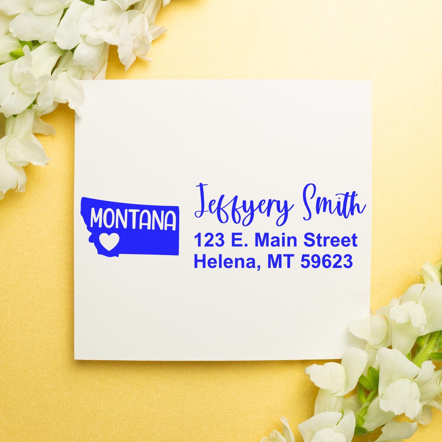 PSI Pre-Inked Montana State Love Customized Address Stamp on white card with blue text, surrounded by white flowers on a gold background.