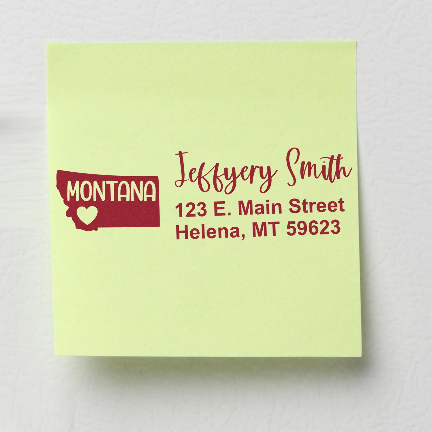 PSI Pre-Inked Montana State Love Customized Address Stamp on a green sticky note, displaying a sample address with a red Montana state outline and heart design.