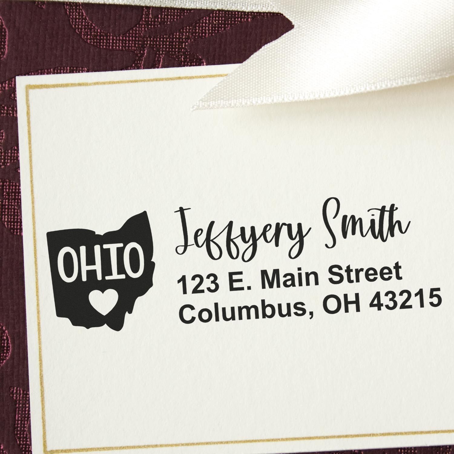 Slim Ohio Custom Address Stamp for Envelopes on a card with Jeffery Smith, 123 E. Main Street, Columbus, OH 43215 in black ink, featuring an Ohio state outline with a heart.