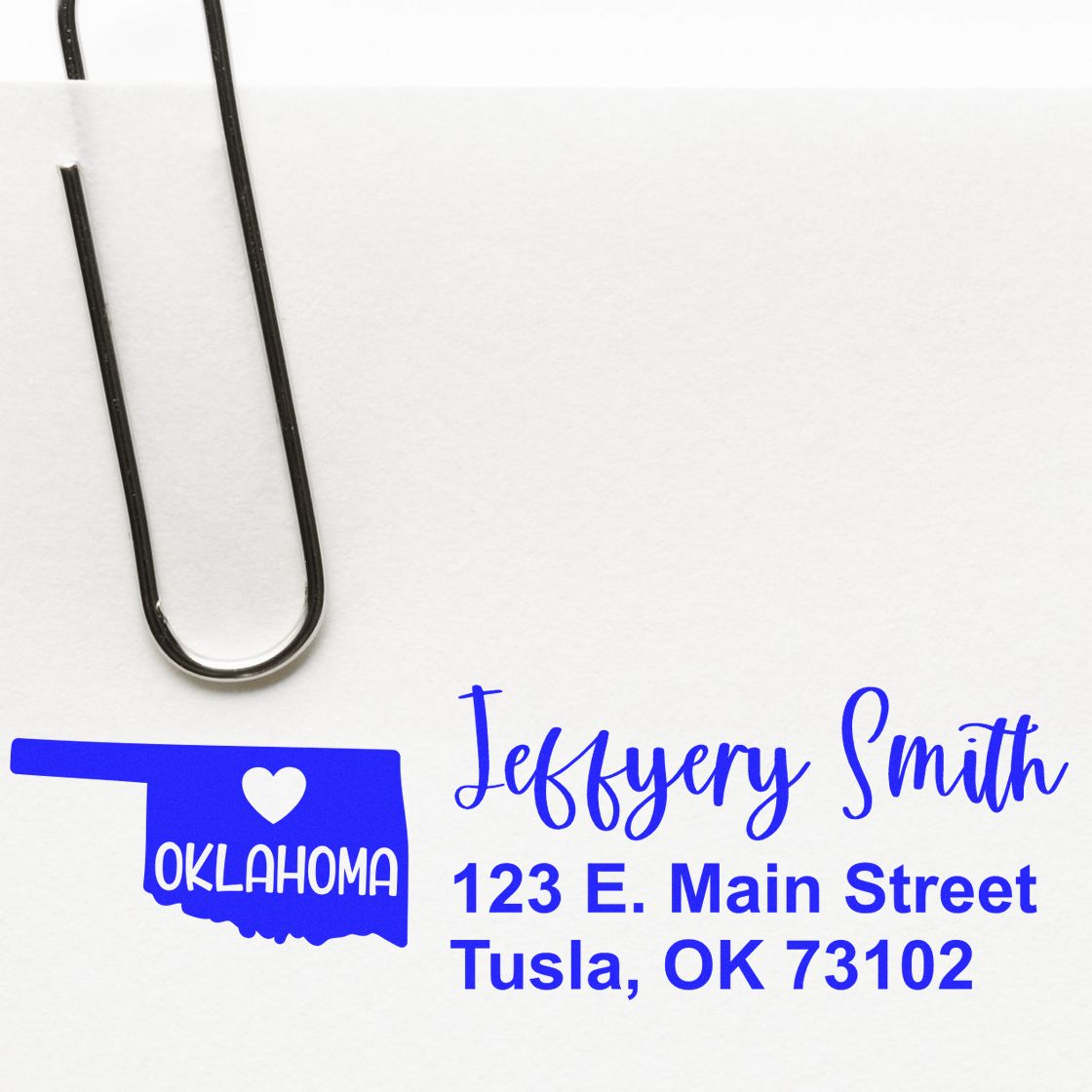 Oklahoma State Love Personalized Address Stamp on white paper with a paperclip, featuring a blue Oklahoma state outline, heart, and custom address in bold blue font.