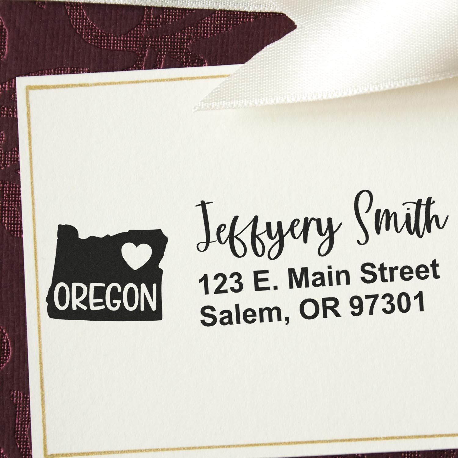 State Love of Oregon Custom Address Stamp Self-Inking on a card with Jeffery Smith, 123 E. Main Street, Salem, OR 97301 in black ink, featuring an Oregon state outline with a heart.