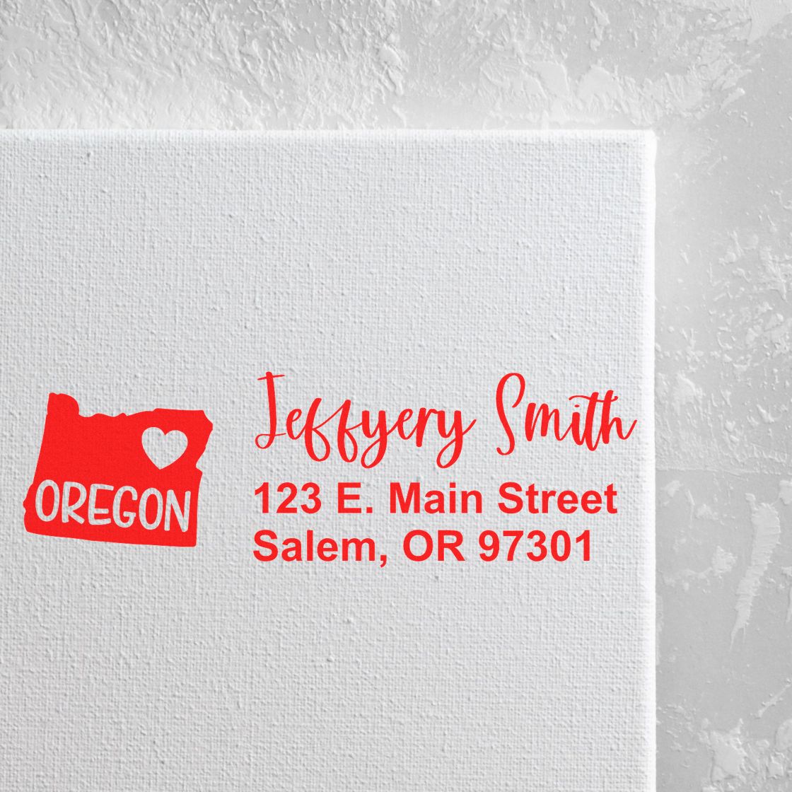 PSI Pre-Inked Oregon State Love Customized Address Stamp on white canvas, featuring a red Oregon map with a heart and personalized address in red script.