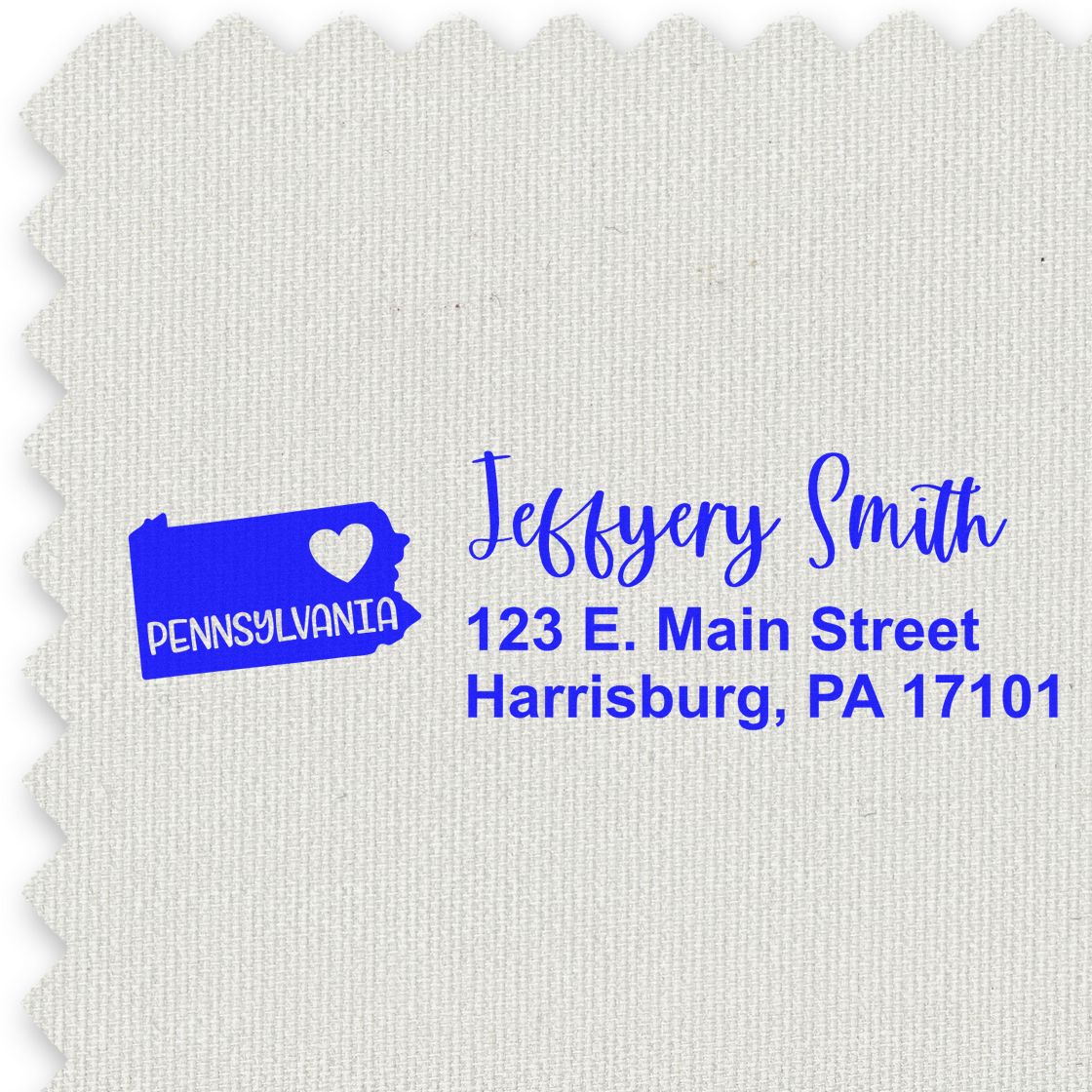 Pennsylvania State Love Personalized Address Stamp on textured fabric, featuring a heart design and sample address in blue text: Jeffery Smith, 123 E. Main Street, Harrisburg, PA 17101.