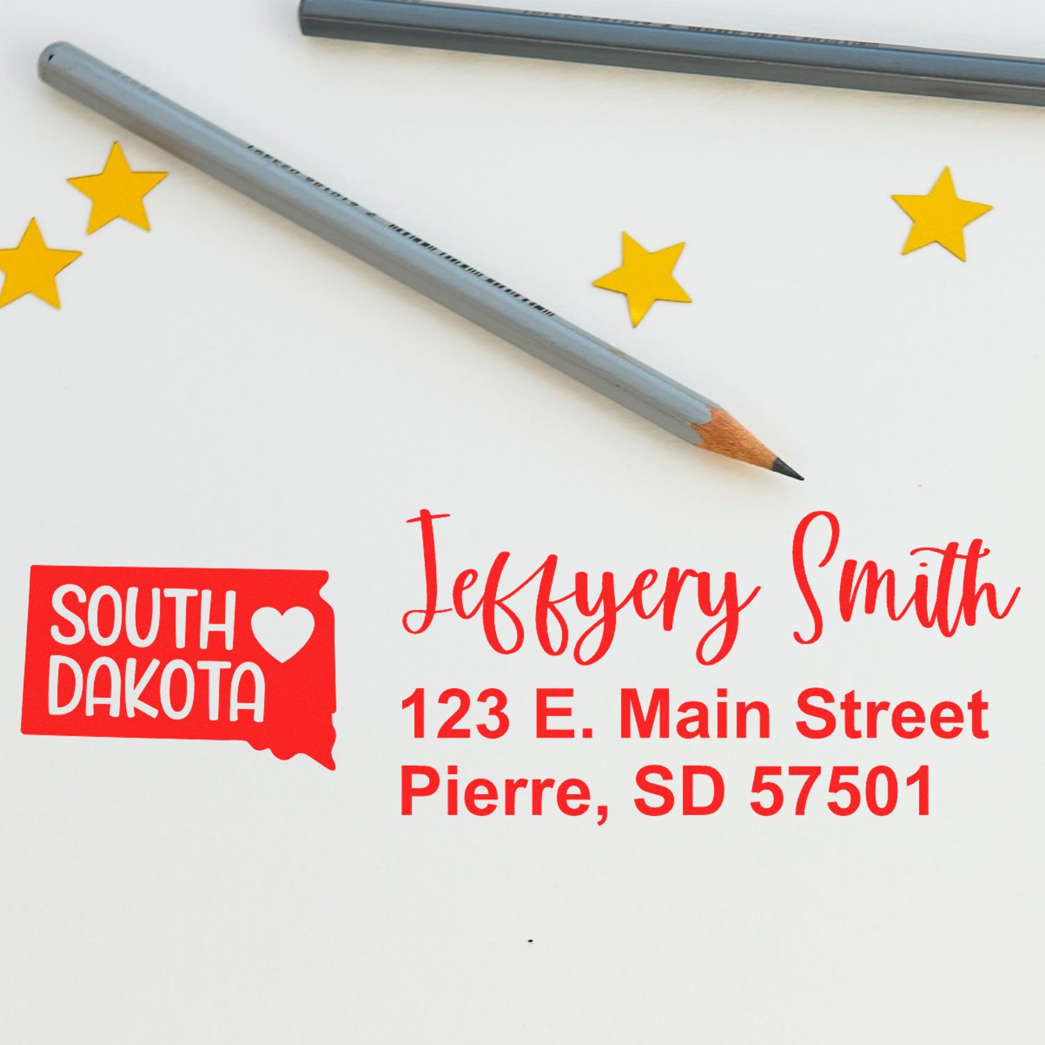 Image of the South Dakota State Love Personalized Address Stamp imprint on paper, featuring a red state outline with a heart, alongside a pencil and yellow stars.