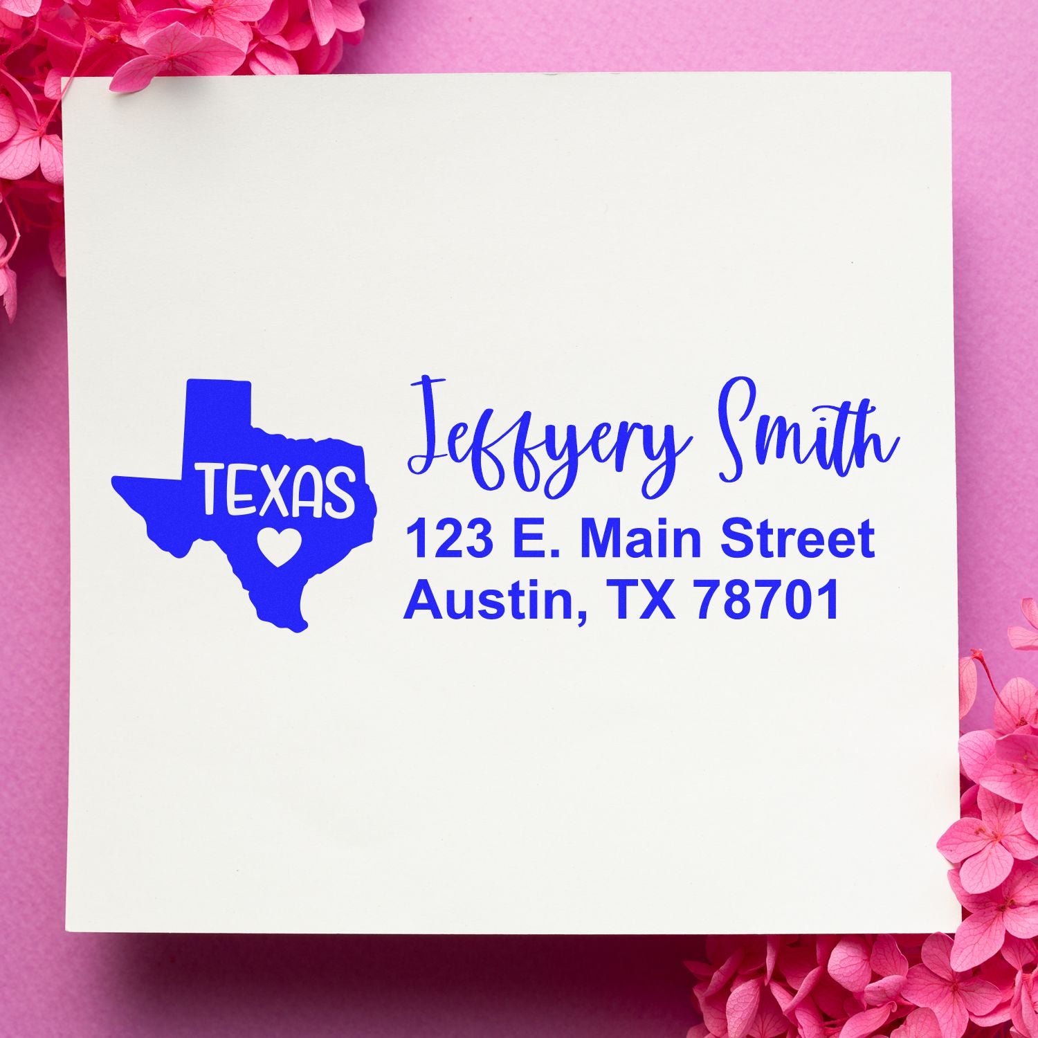 Texas State Love Personalized Address Stamp on white paper with blue text, featuring a Texas outline and heart. Placed on a pink background with pink flowers.