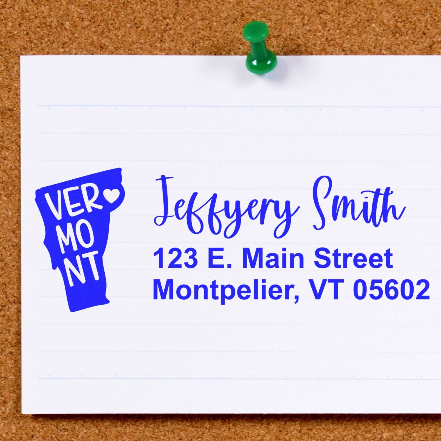 PSI Pre-Inked Vermont State Love Customized Address Stamp on a corkboard, displaying a Vermont map design with address: Jeffery Smith, 123 E. Main Street, Montpelier, VT 05602.