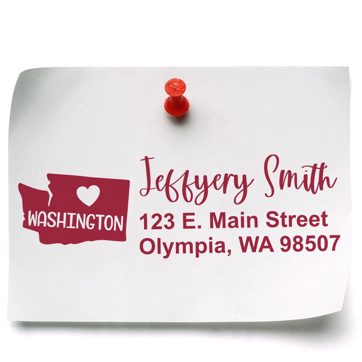 Image of a paper with a red pushpin featuring the Washington State Love Personalized Address Stamp design, showing a heart inside the state outline and sample address text in red.