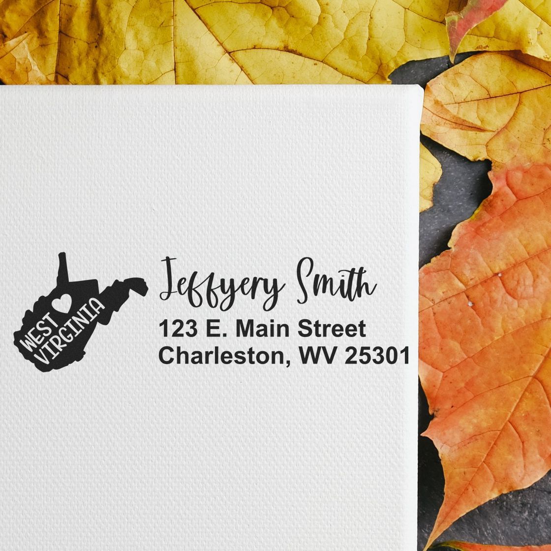 State Love of West Virginia Custom Address Stamp Self-Inking on white paper with autumn leaves background, featuring a map outline and personalized address for Jeffery Smith in Charleston, WV.