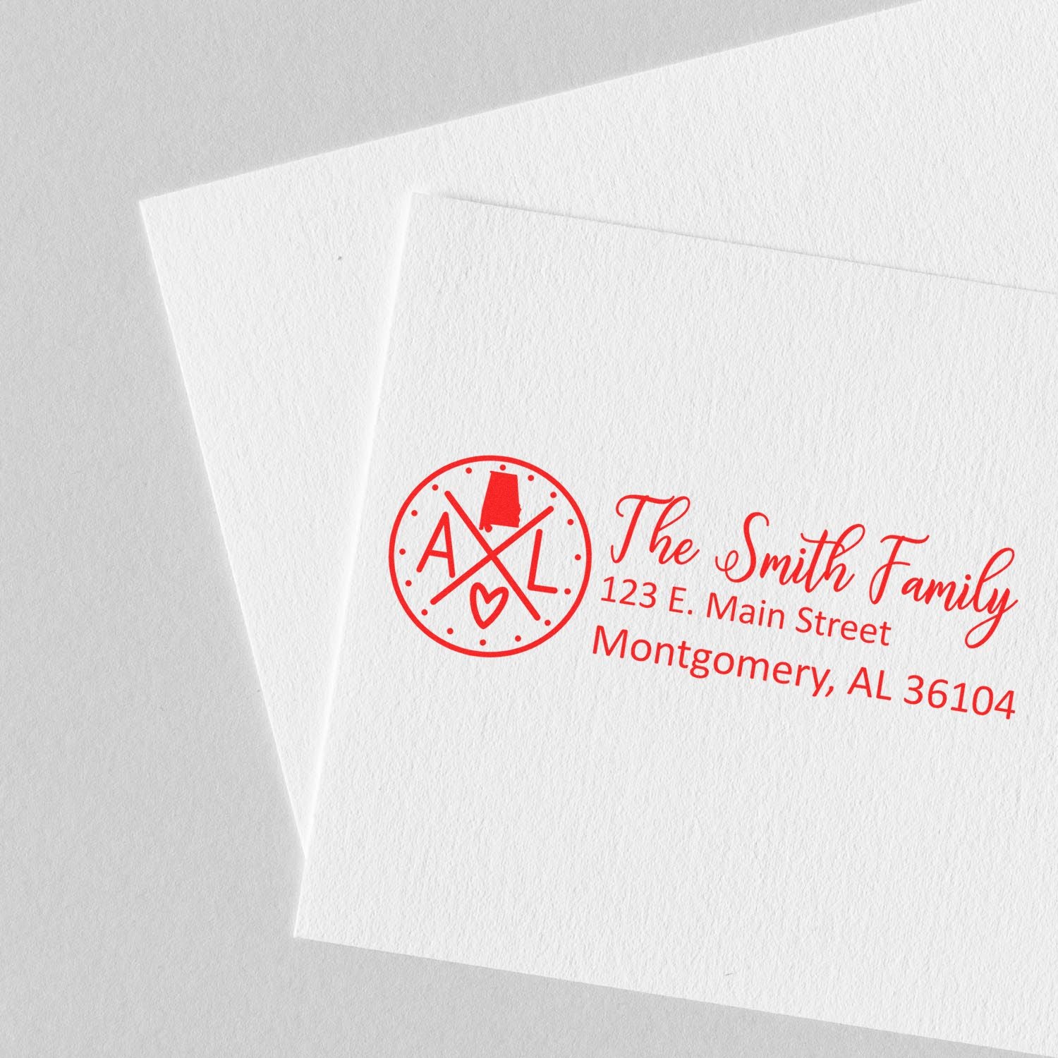 PSI Pre-Inked Alabama State Pride Customized Address Stamp on white paper, featuring a red design with AL and a heart, personalized with The Smith Family and their address in Montgomery, AL.