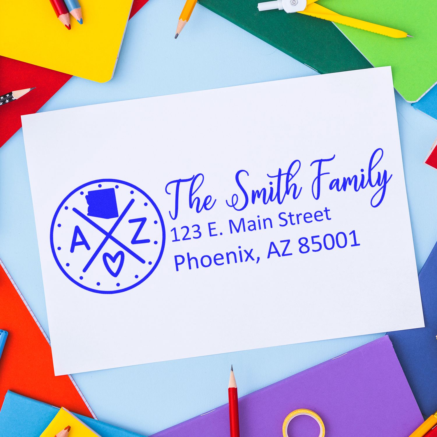 Arizona State Pride Customized Address Stamp on white paper with 'The Smith Family' and address, surrounded by colorful stationery on a vibrant background.