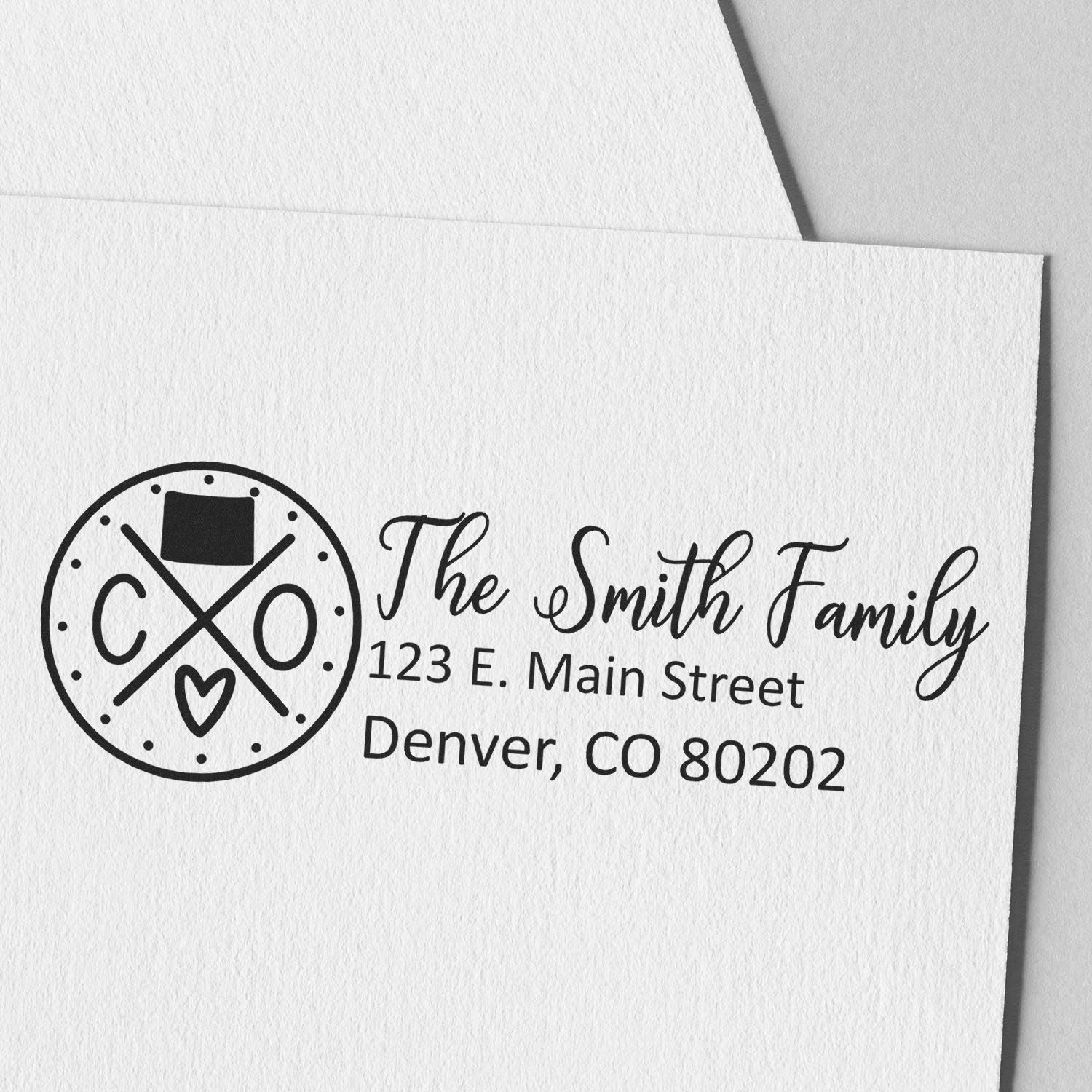 Self-Inking State Love of Colorado Custom Address Stamp on white paper, featuring a circular design with CO and a heart, personalized with The Smith Family and Denver address.