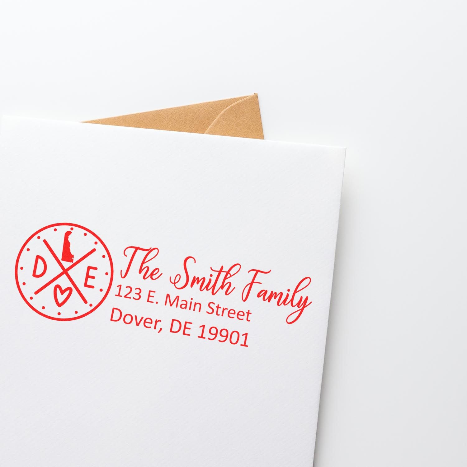 Delaware State Pride Customized Address Stamp in red ink on a white envelope, featuring a circular design with DE and a heart, personalized with The Smith Family and an address in Dover, DE.