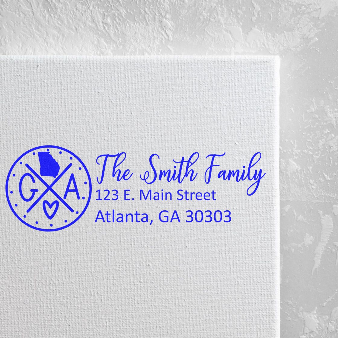 Georgia State Pride Customized Address Stamp featuring a circular design with GA and a heart, personalized with The Smith Family and an Atlanta address, stamped on a white textured surface.