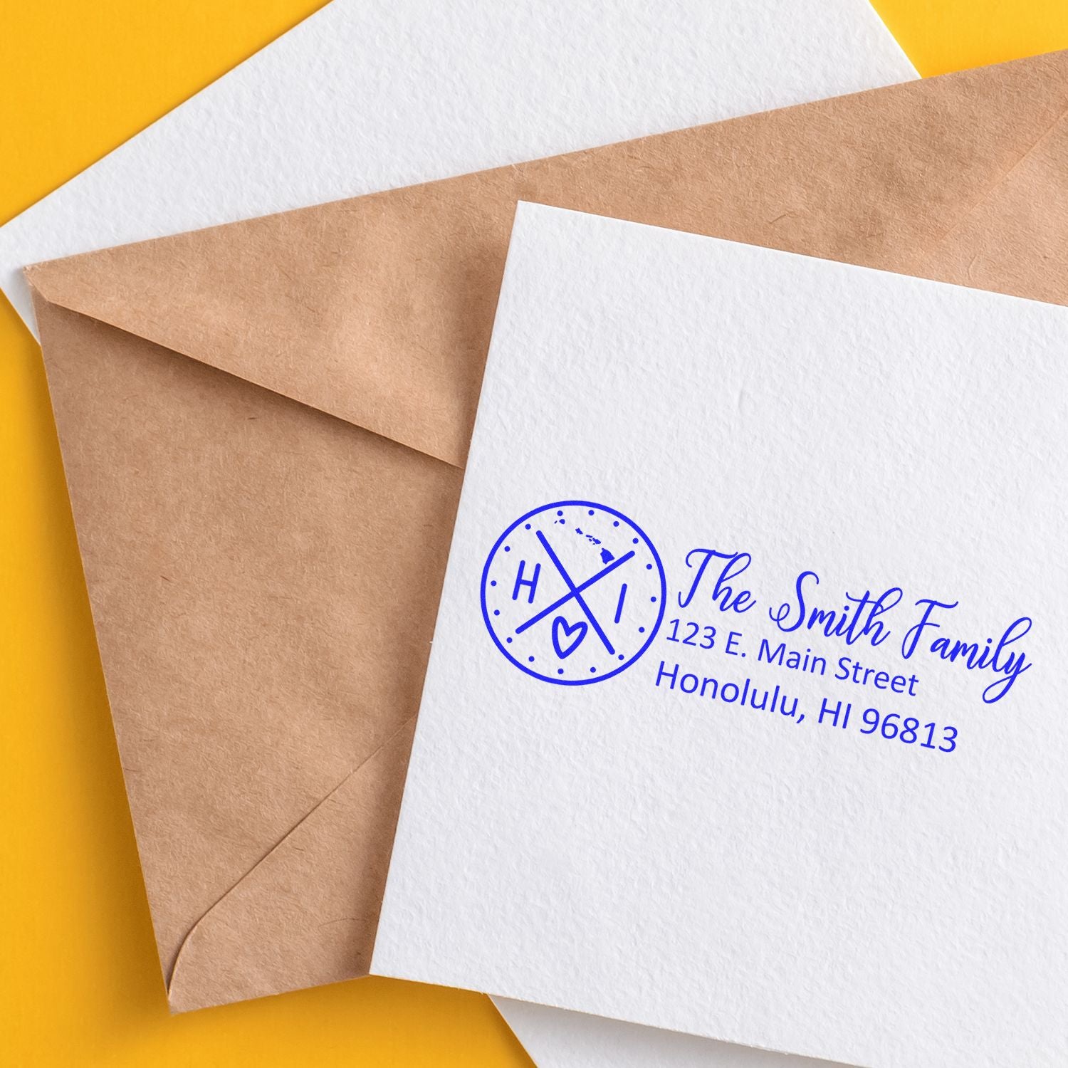 Hawaii State Pride Customized Address Stamp on a white envelope with a brown paper envelope beneath, featuring a blue design with HI and a heart, alongside The Smith Family address in Honolulu.