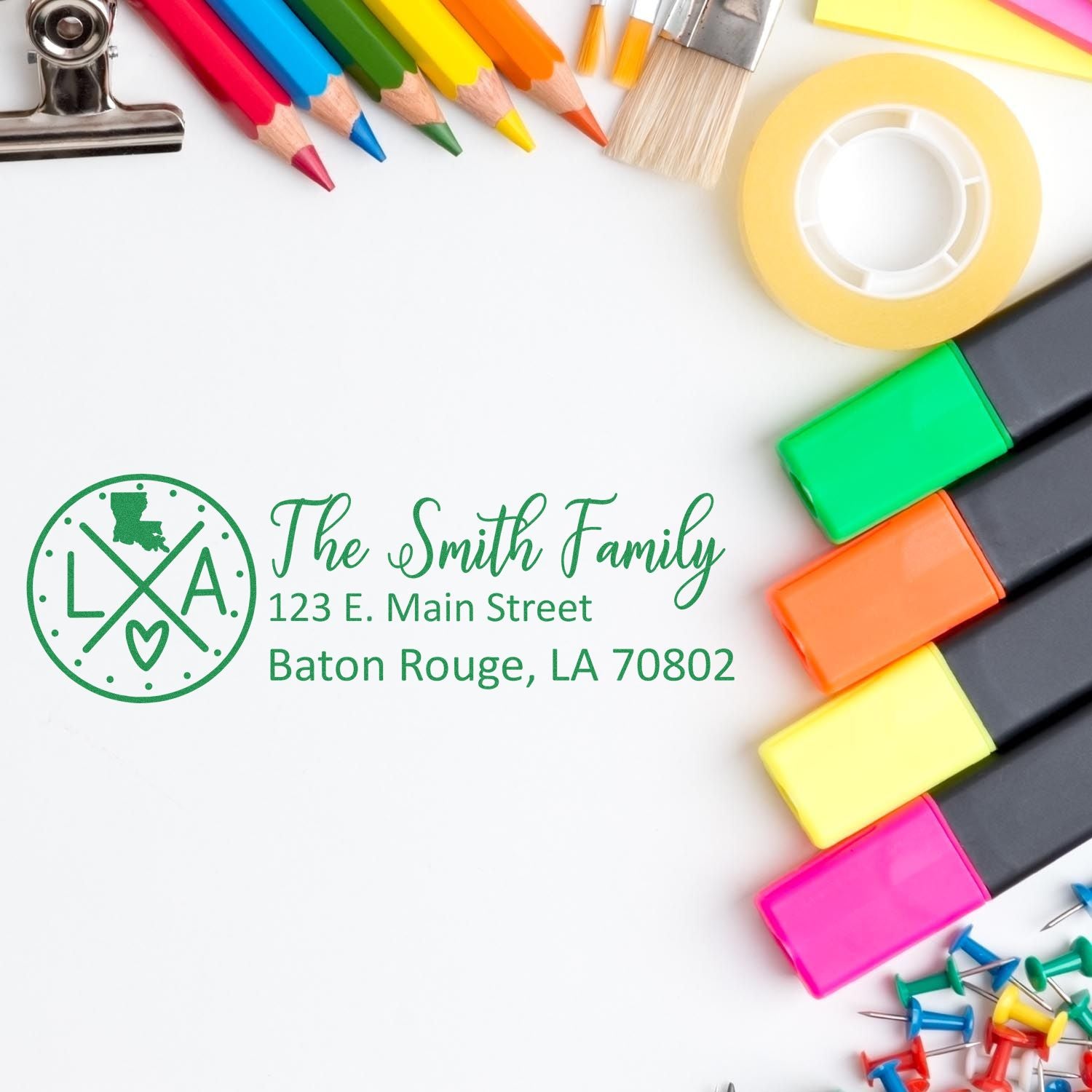 Louisiana State Pride Customized Address Stamp on white paper, surrounded by colorful markers, pencils, tape, and a paintbrush, displaying The Smith Family, 123 E. Main Street, Baton Rouge, LA 70802.