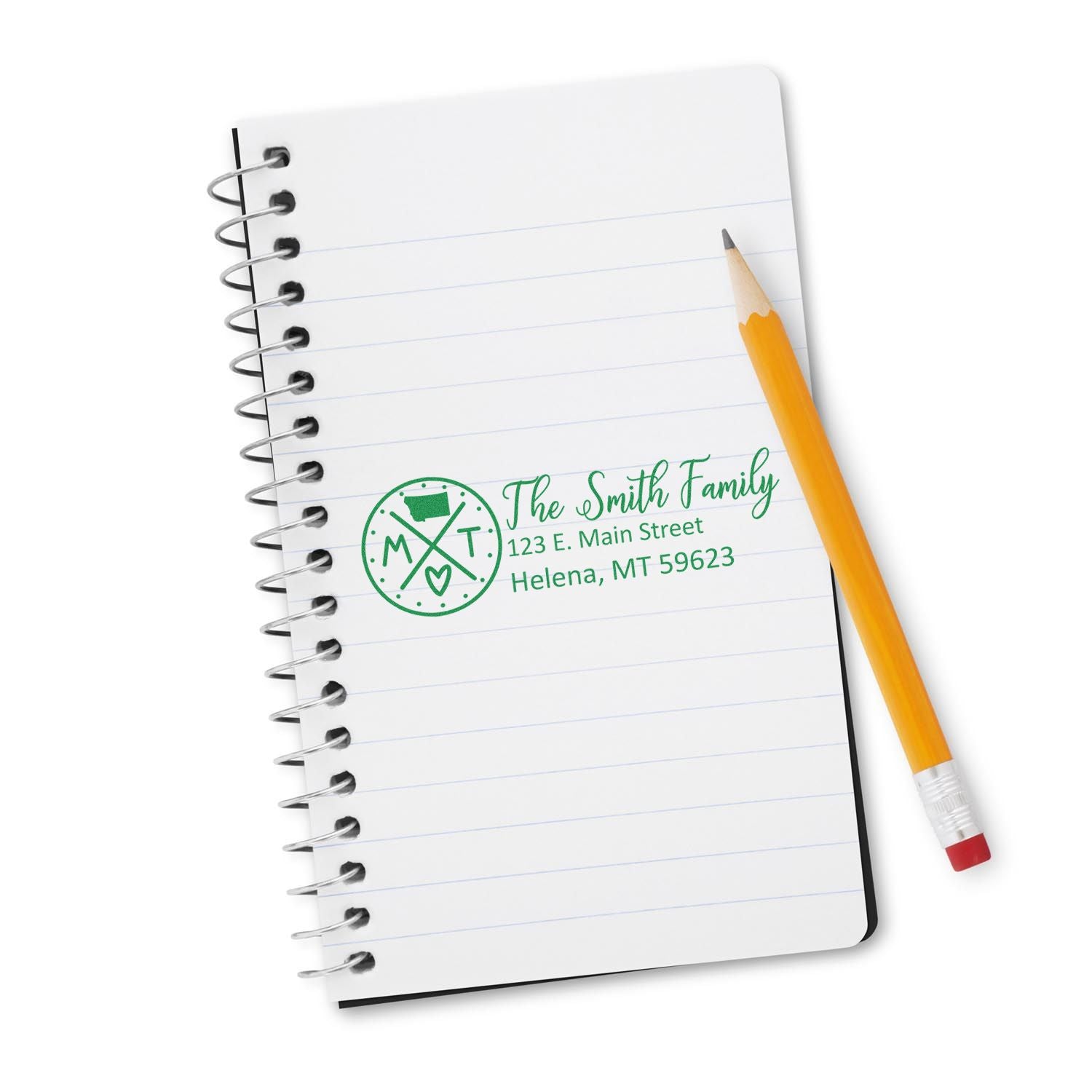 A notebook with a pencil and a green imprint of the Self-Inking State Love of Montana Custom Address Stamp, featuring The Smith Family and an address in Helena, MT.