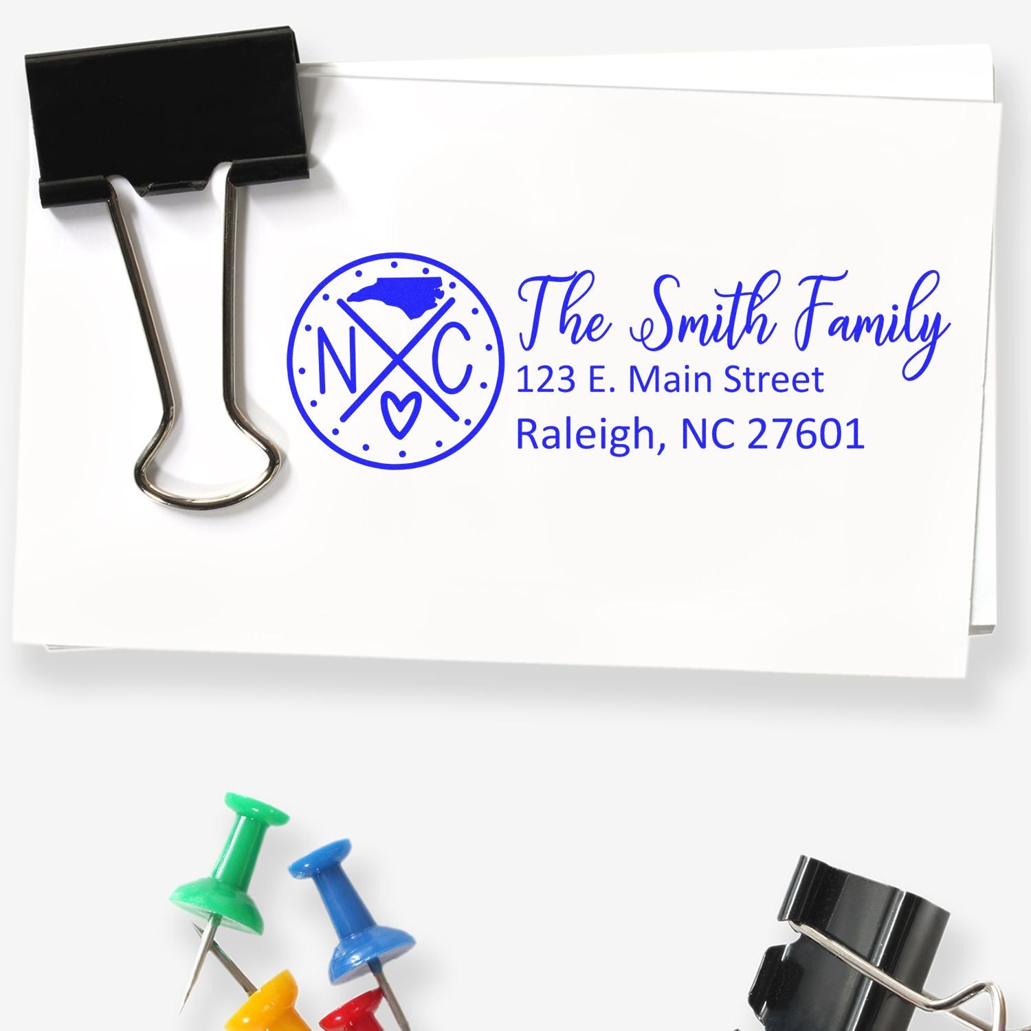 North Carolina State Pride Customized Address Stamp on an envelope with The Smith Family and address. Includes a binder clip and colorful push pins.