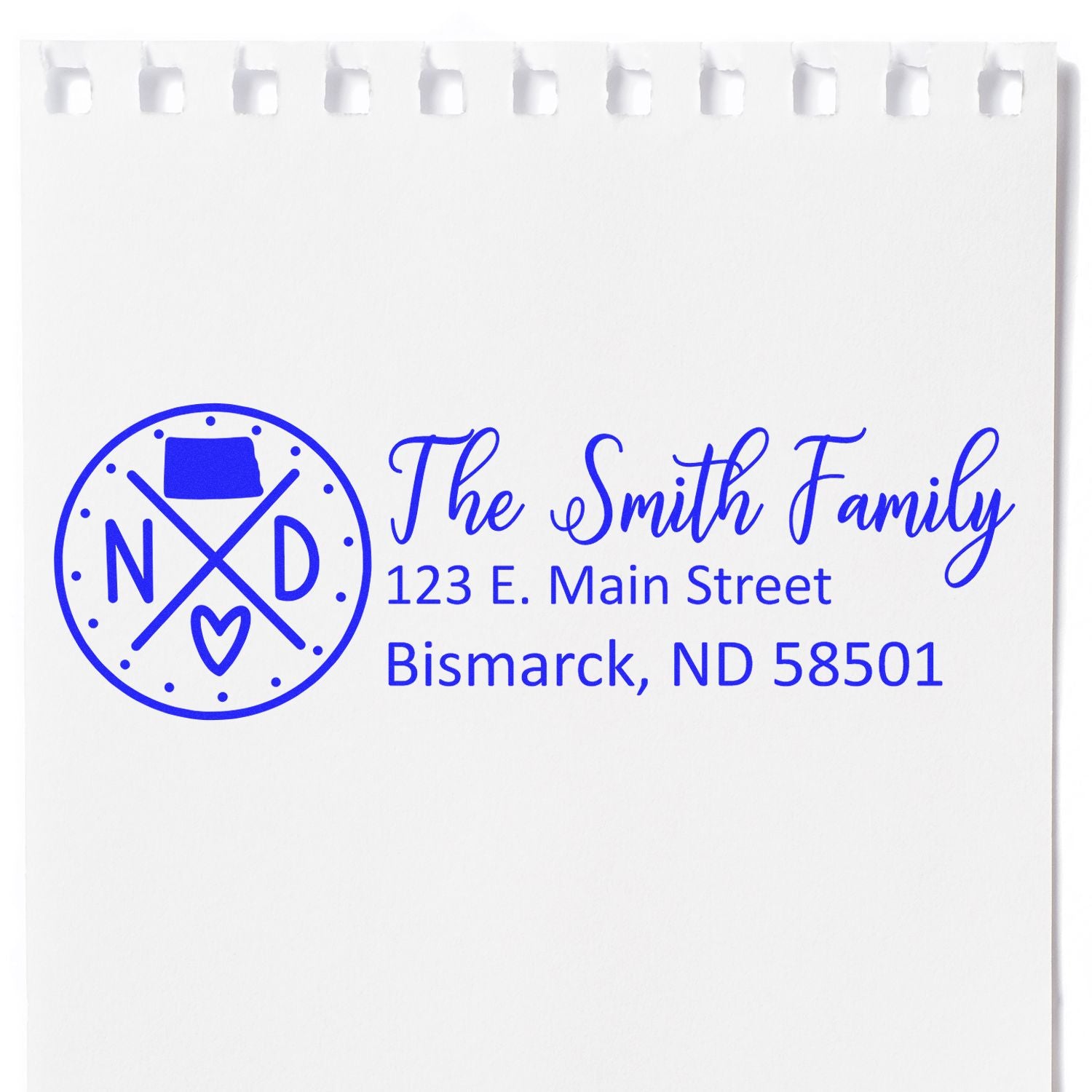 Self-Inking State Love of North Dakota Custom Address Stamp on white paper, featuring a blue design with ND and a heart, personalized with The Smith Family and Bismarck address.