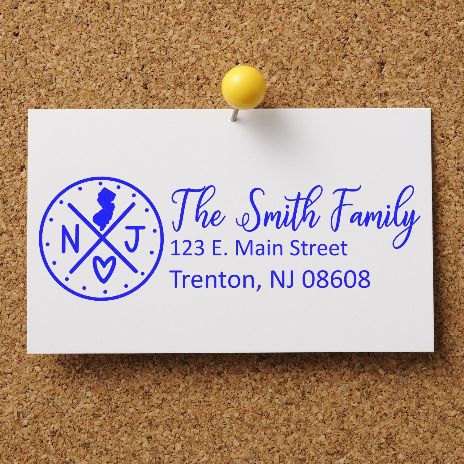 PSI Pre-Inked New Jersey State Pride Customized Address Stamp on a card pinned to a corkboard, displaying The Smith Family with an NJ state emblem and address in blue ink.