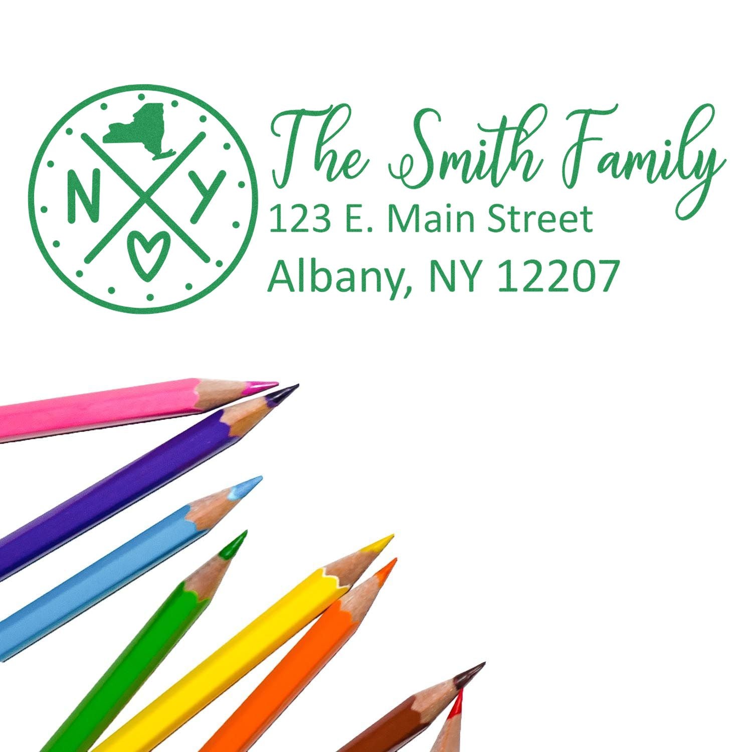 New York State Pride Customized Address Stamp featuring a green design with NY and a heart. Displays The Smith Family, 123 E. Main Street, Albany, NY 12207 alongside colorful pencils.