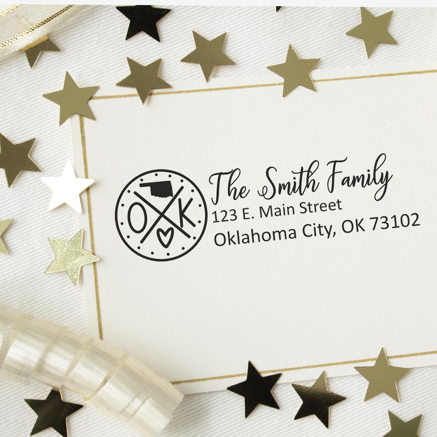 Oklahoma State Pride Customized Address Stamp on an envelope surrounded by gold stars. The stamp features a circular design with OK and a heart, displaying a sample address for The Smith Family.