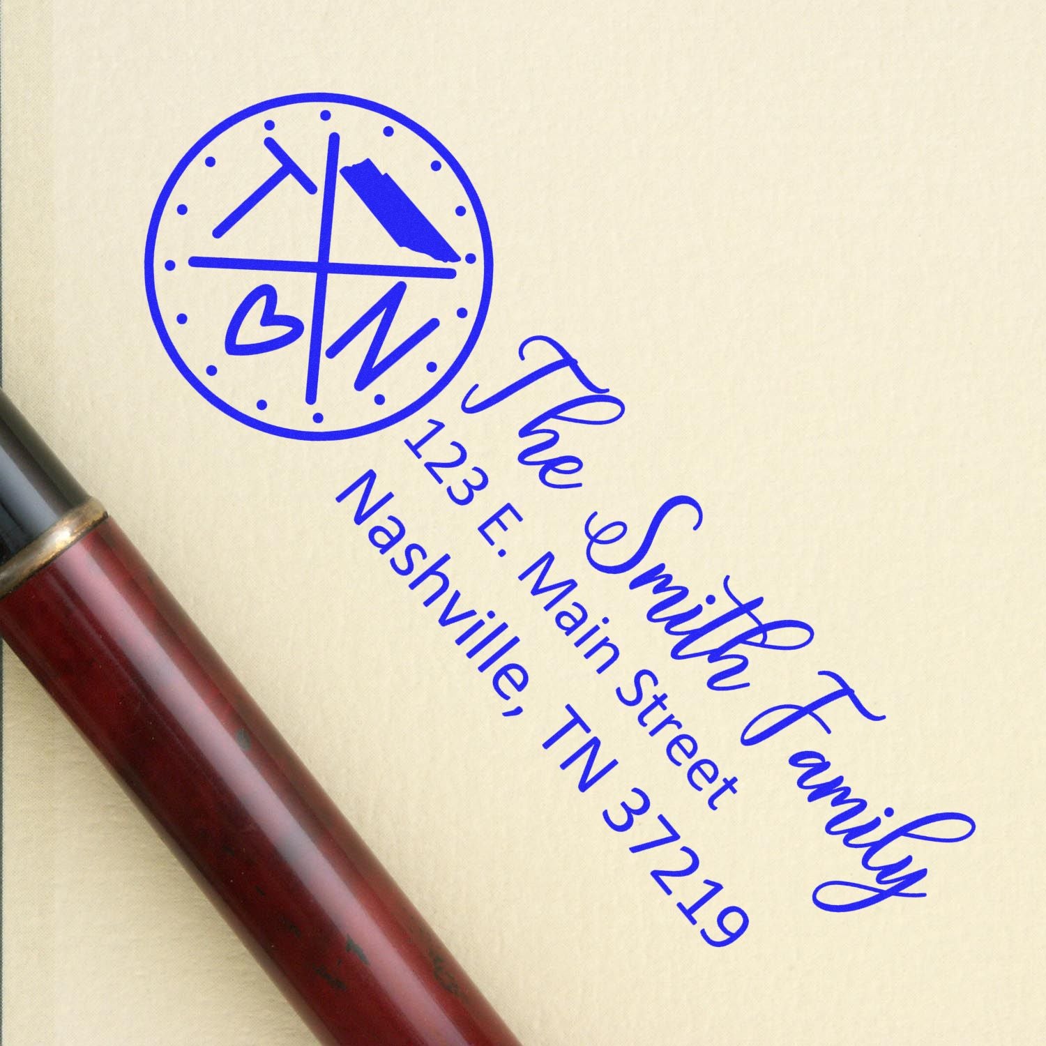 Tennessee State Pride Customized Address Stamp in blue ink on an envelope, featuring a circular TN design and personalized address for The Smith Family in elegant script. Pen nearby.