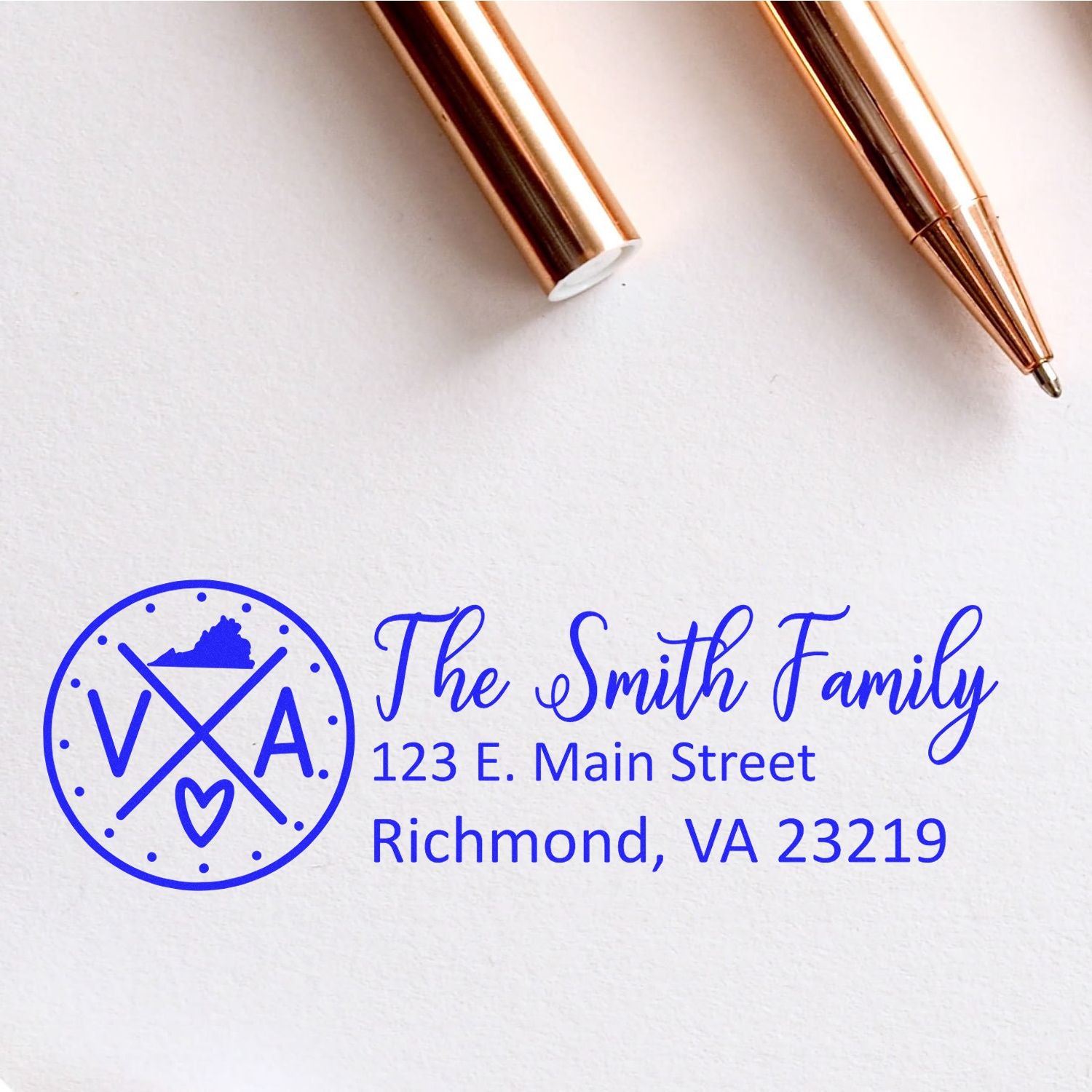 Virginia State Pride Customized Address Stamp featuring a blue VA design with a heart, personalized for The Smith Family at 123 E. Main Street, Richmond, VA 23219, next to a rose gold pen.