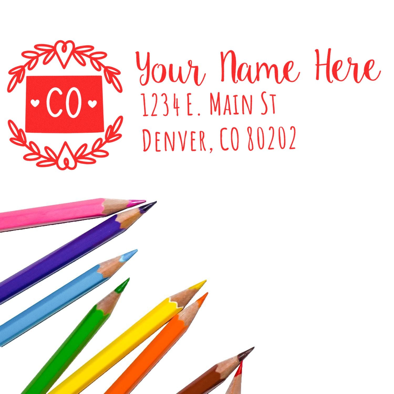 Image of a PSI Pre-Inked Colorado State Customized Address Stamp with a red design, featuring Your Name Here and a Denver address. Colorful pencils are arranged below the stamp.