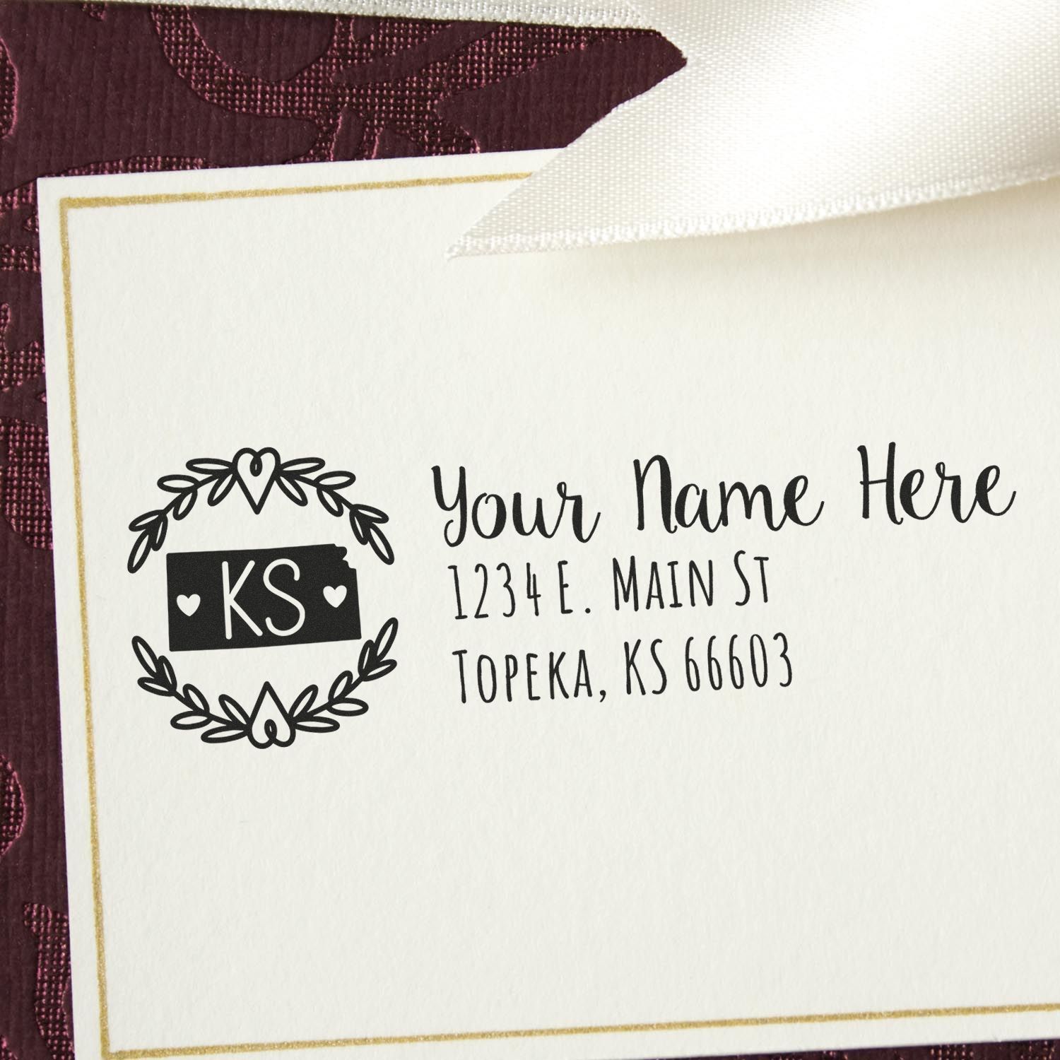 Kansas State Custom Return Address Stamp on an envelope, featuring a decorative wreath design with KS in the center. The stamp includes space for a name and address in elegant script.