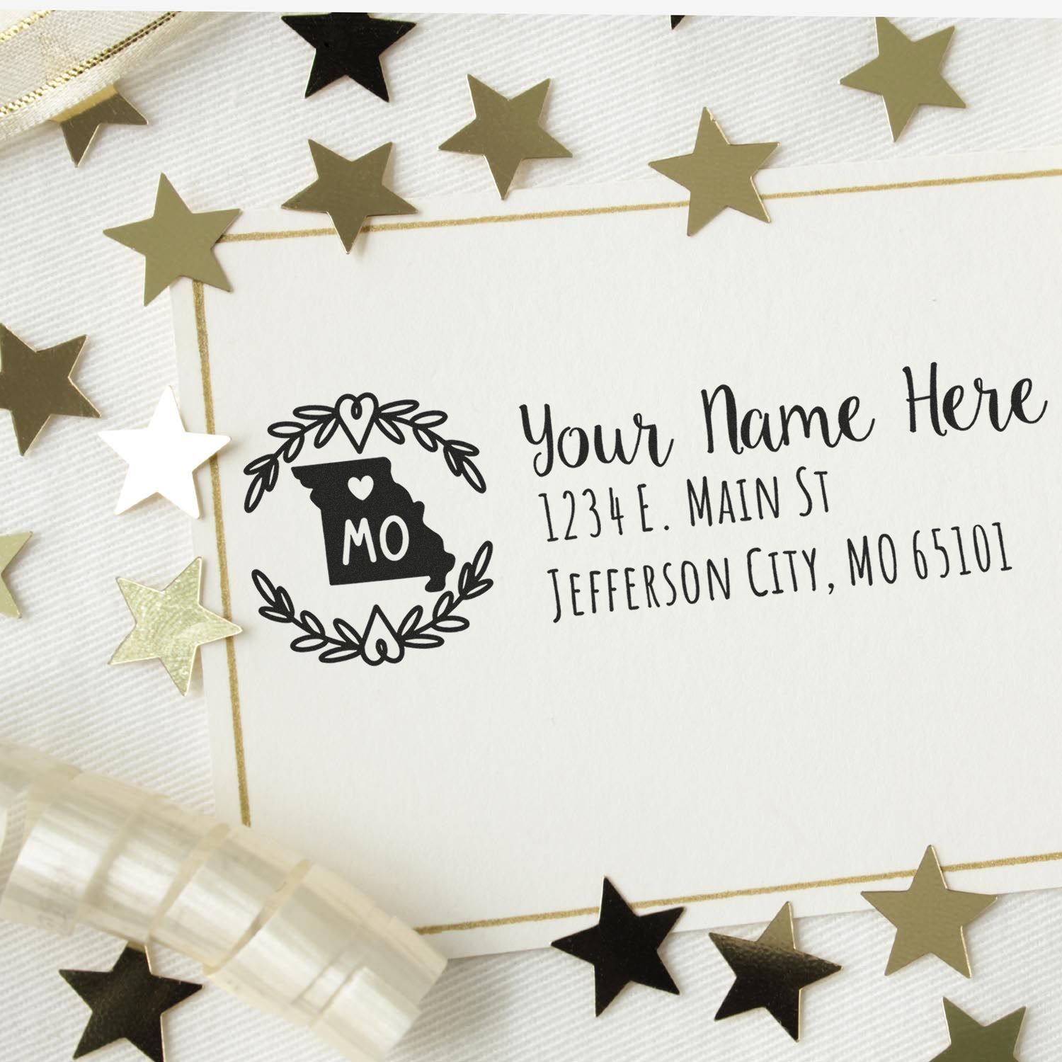 Self-Inking State Wreath of Missouri Address Stamp on a card with gold stars and ribbon. Displays Your Name Here and a Missouri state outline with a heart and wreath design.