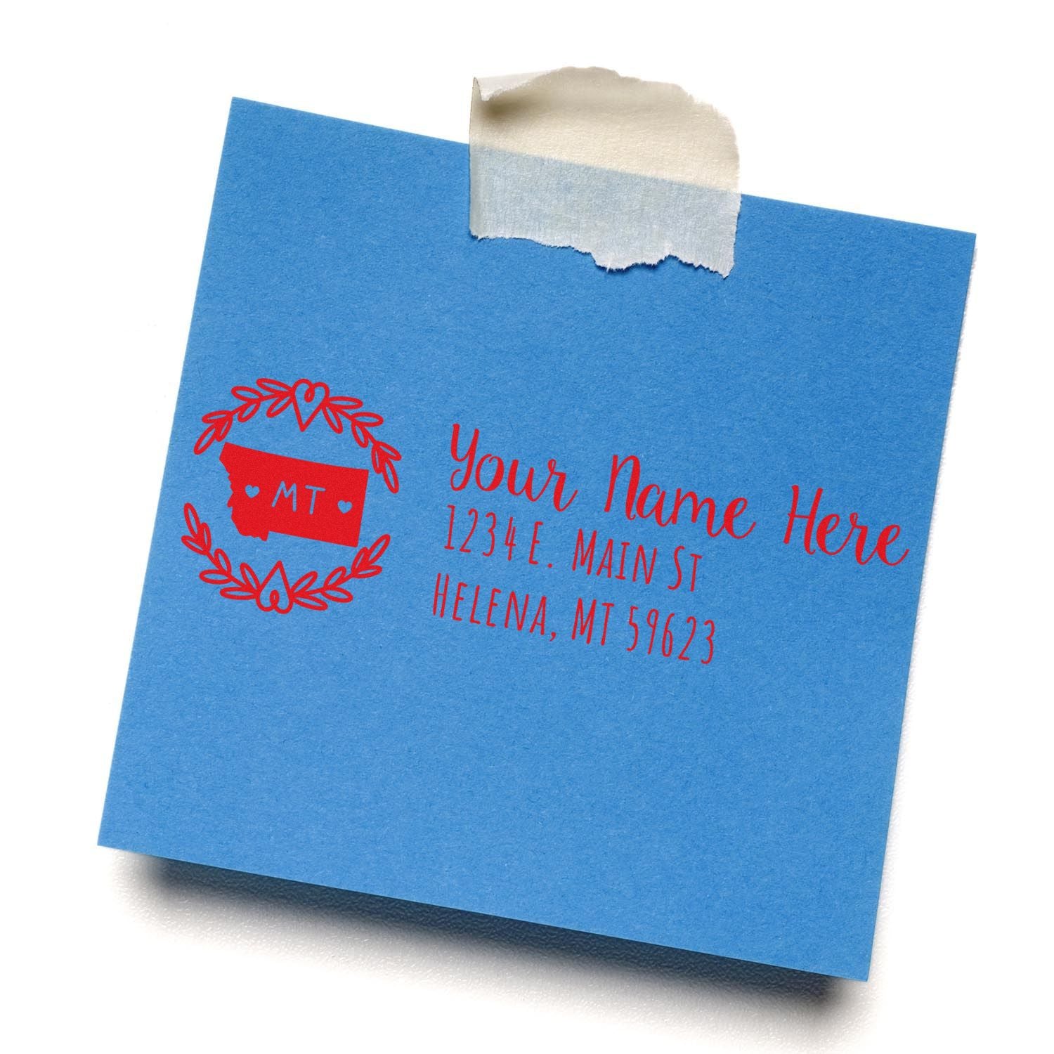 Blue paper with a red Montana State Custom Return Address Stamp design, featuring a state outline and laurel wreath, personalized with Your Name Here and an address in Helena, MT.