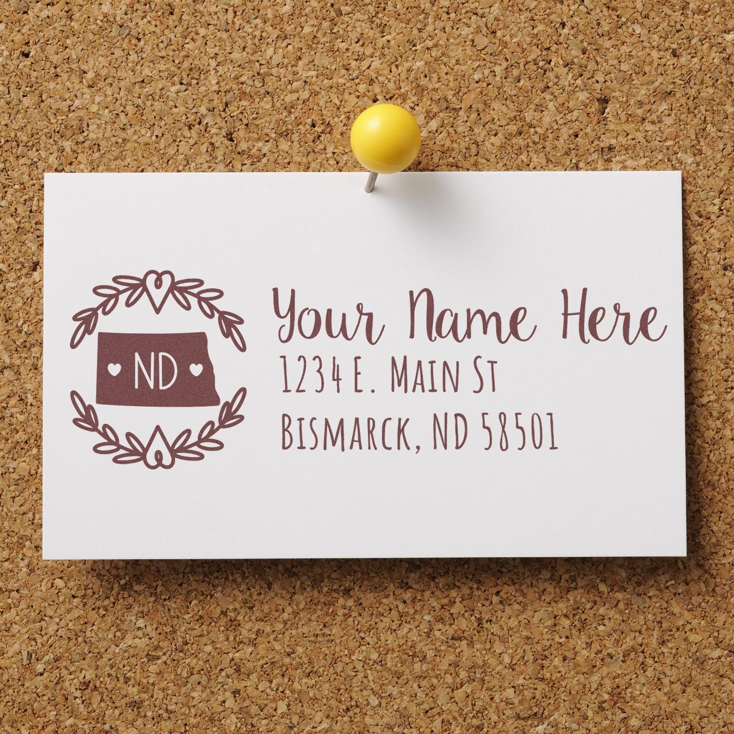 North Dakota State Custom Return Address Stamp on a card pinned to a corkboard, featuring a decorative ND state outline with hearts and space for personalized address details.