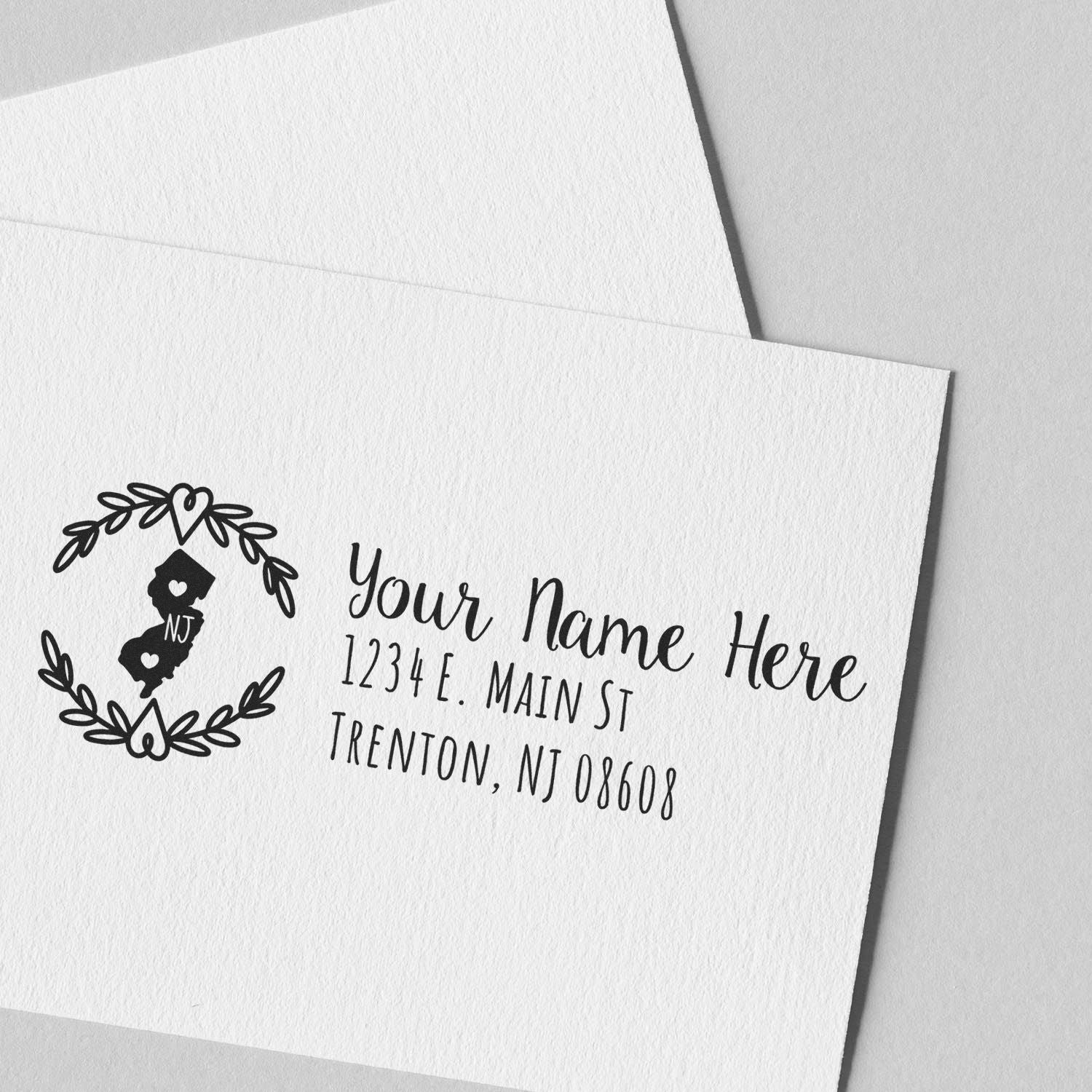 New Jersey State Custom Return Address Stamp on white envelope, featuring a heart design with NJ inside, personalized with name and address in elegant script. Perfect for adding a personal touch.